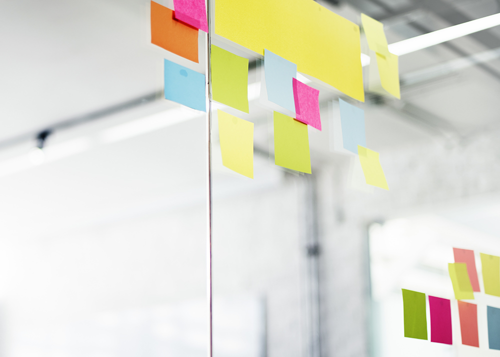 Closeup of colorful blank sticky notes on office glass
